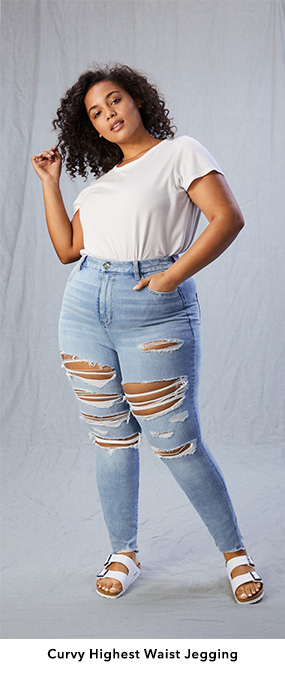 Woman wearing ripped, light wash Curvy Highest Waist Jeggings with a white t-shirt