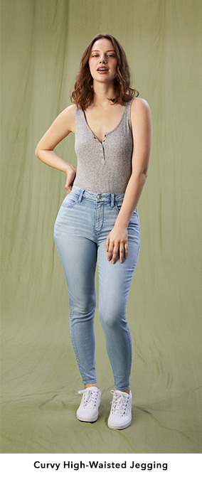 Woman wearing light wash Curvy High-Waisted Jeggings with a gray tank top